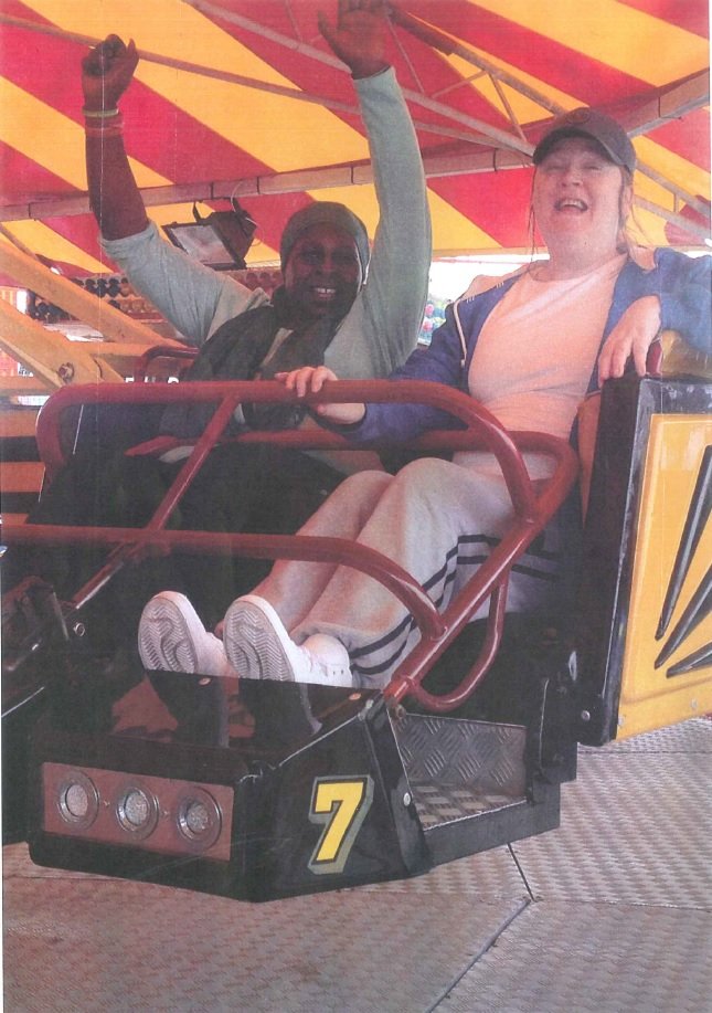 Two women ride a carousel together on a day trip to Brighton