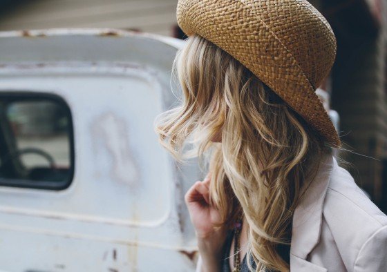 Young woman wearing a hat, face covered by her hair