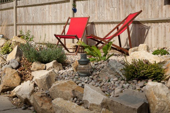 Deck chairs in the sunshine in the garden of a hostel