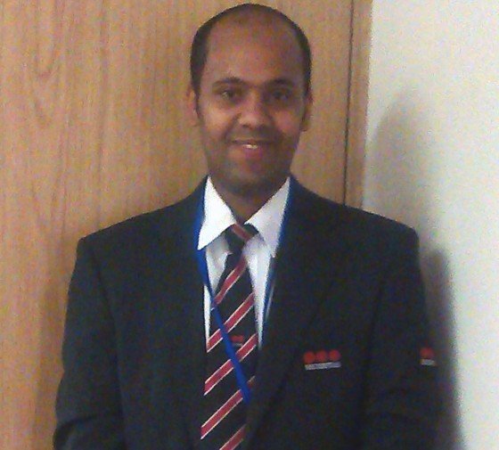 Amal smiling in a suit ready to go to work
