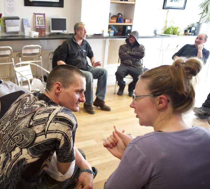 Women and man talking at group session: Supporting people with mental health issues