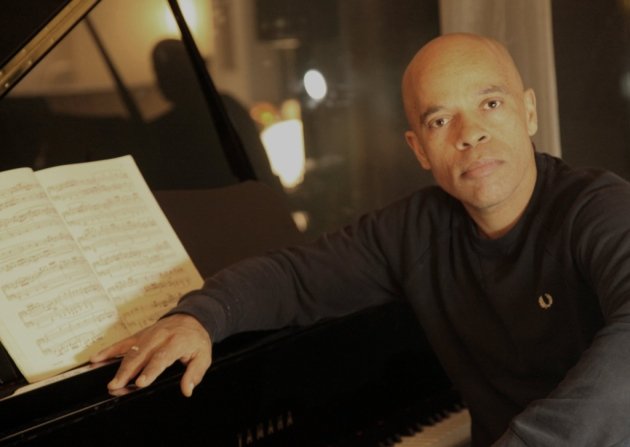 Composer Vince Pope, seated at piano