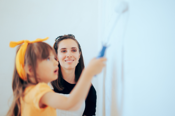 Photograph of a woman and a little girl painting a room
