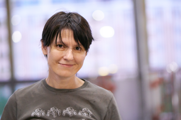 Photograph of a a woman with short black hair and a grey t-shirt