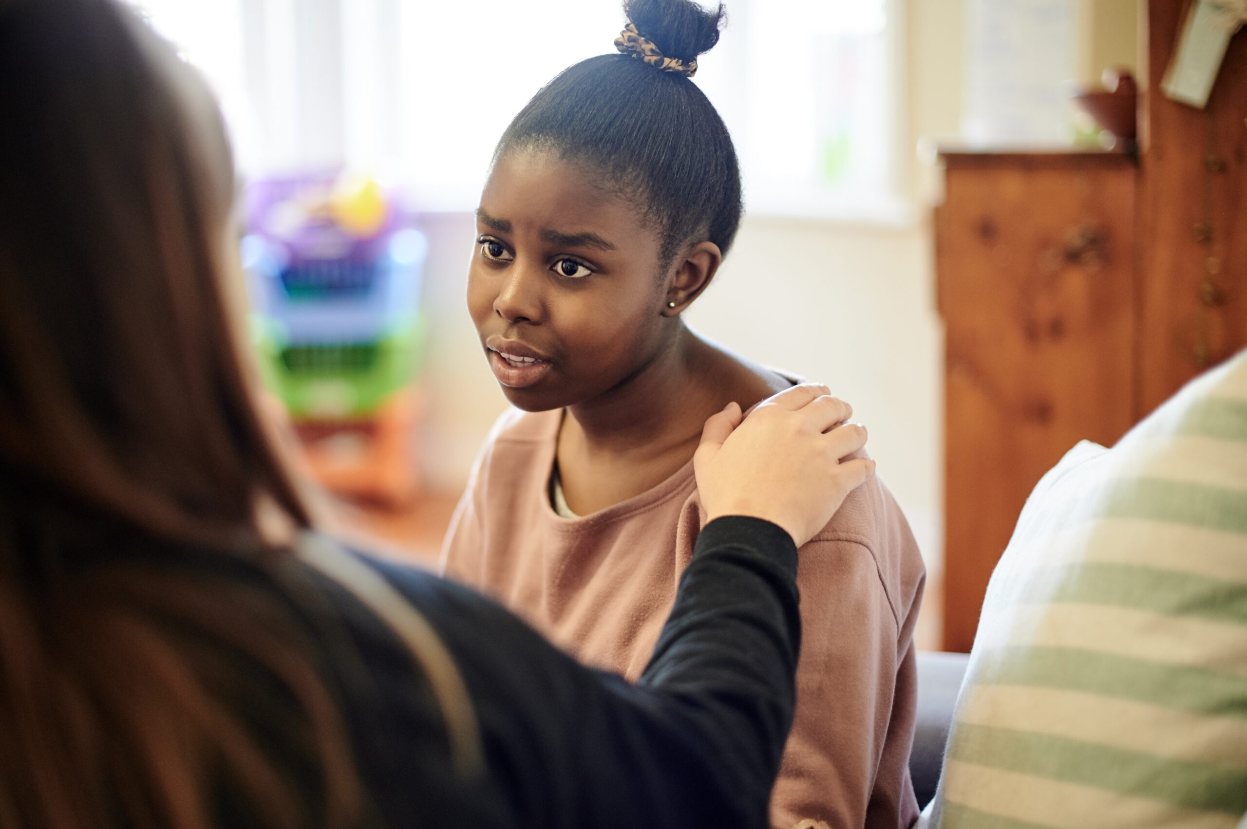 Photograph of a teenaged girl being comforted by another women 
